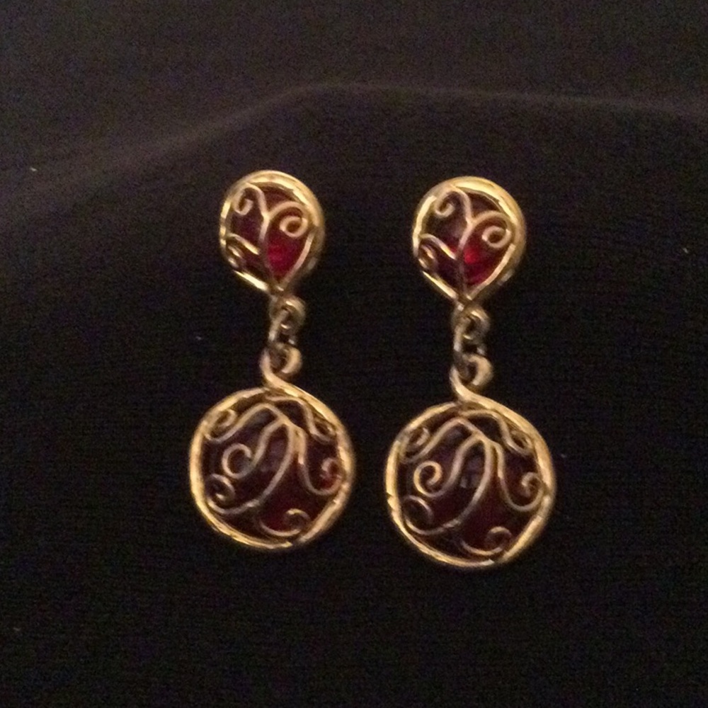 Red translucent glass dangling earrings with gold designs.